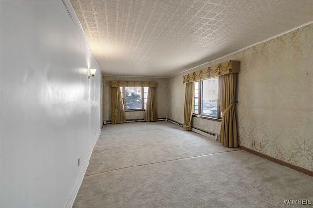 spare room with crown molding, baseboards, light colored carpet, and an ornate ceiling