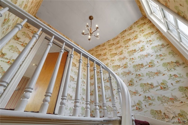 interior space with a chandelier and wallpapered walls