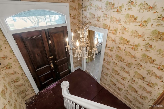 entryway with wallpapered walls, baseboards, and a notable chandelier