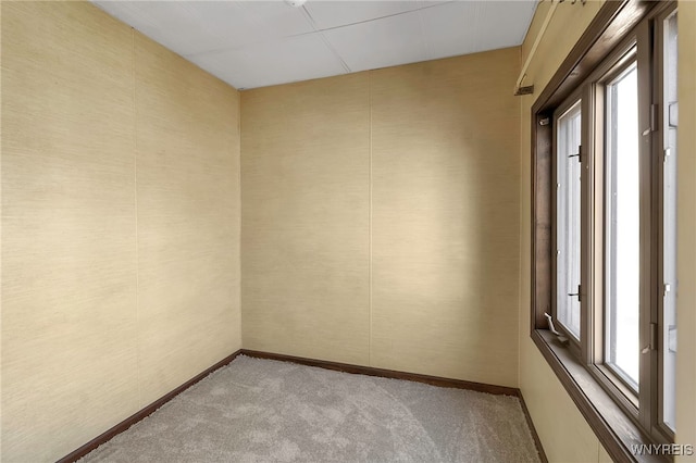 unfurnished room featuring baseboards and light colored carpet