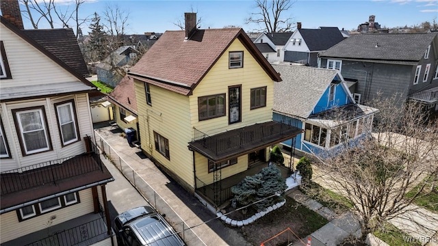 rear view of property with a residential view and a chimney
