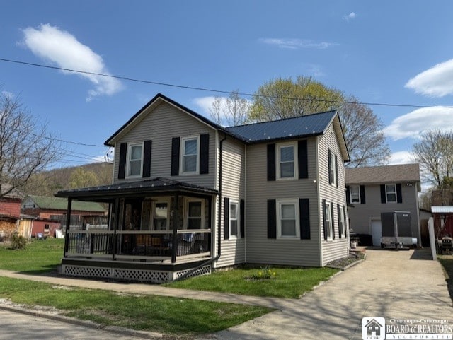 view of front facade featuring a porch, driveway, and a front yard