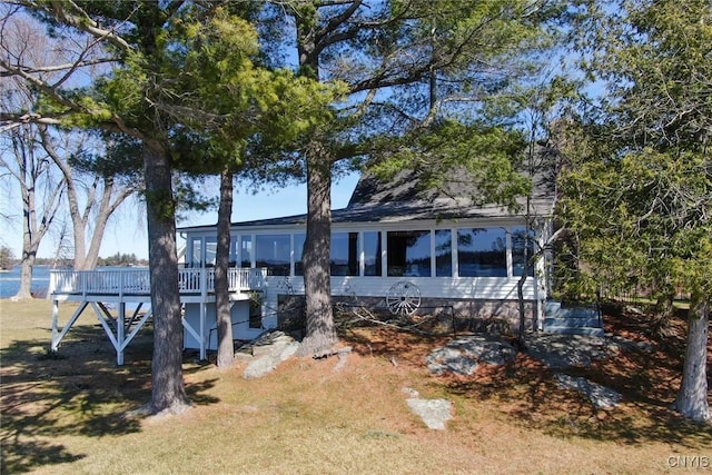 rear view of property featuring a sunroom, a deck, and stairway