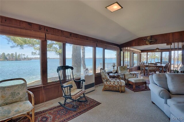 carpeted living room with vaulted ceiling and a water view