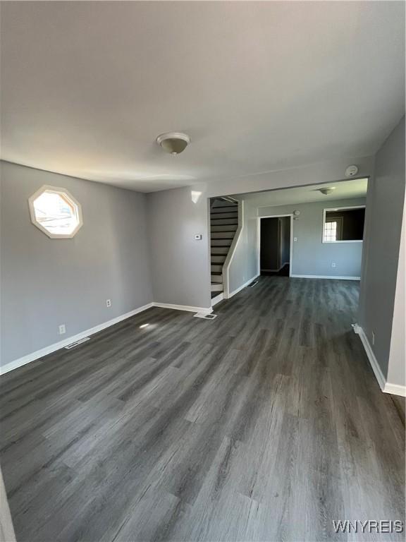 59 Park Ave, Tonawanda-City, NY 14150 - unfurnished room with dark wood finished floors, baseboards, and stairs