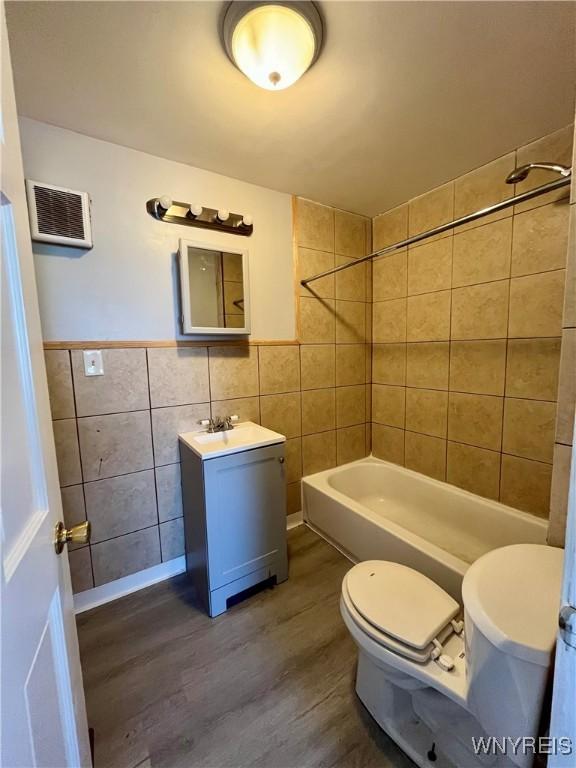 59 Park Ave, Tonawanda-City, NY 14150 - full bath featuring toilet, tile walls, shower / bathtub combination, wood finished floors, and vanity