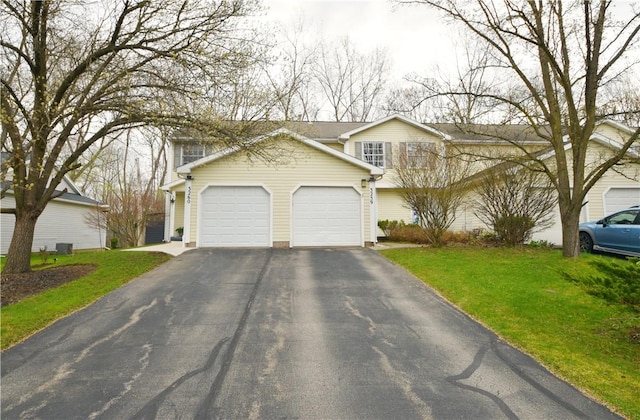 view of front of house featuring a garage, a front lawn, and aphalt driveway