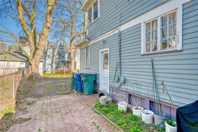 view of side of home with a patio and fence
