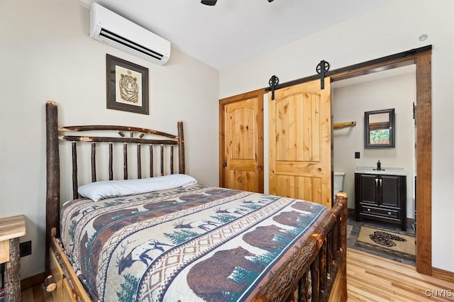 42795 Paynes Lake Camp Rd, Antwerp, NY 13608 - bedroom with an AC wall unit, a ceiling fan, a barn door, and light wood-style flooring