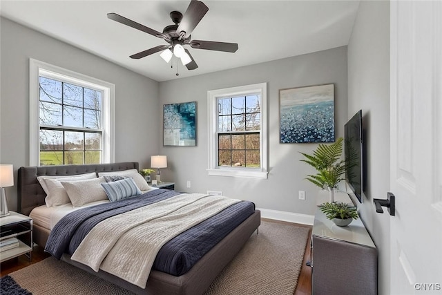 bedroom with multiple windows, baseboards, and dark wood-type flooring