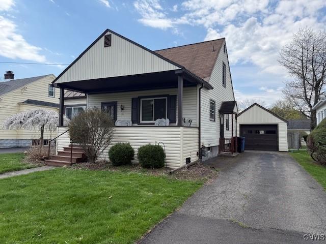 bungalow-style home with an outdoor structure, a detached garage, driveway, and a front lawn