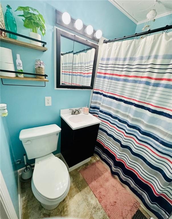 full bath featuring toilet, vanity, crown molding, baseboards, and a shower with shower curtain