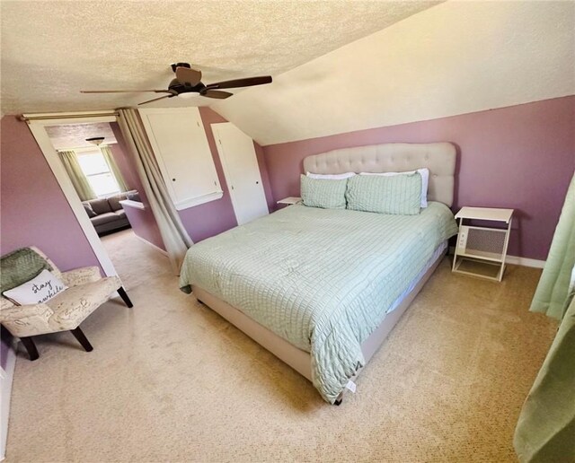 bedroom with vaulted ceiling, a ceiling fan, carpet flooring, and a textured ceiling