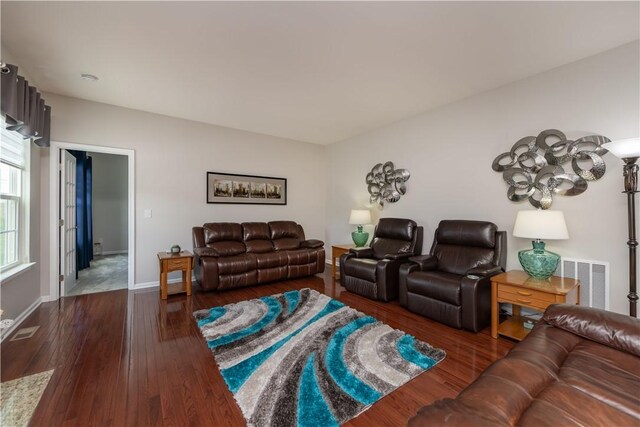 living room featuring baseboards, dark wood-type flooring, and visible vents
