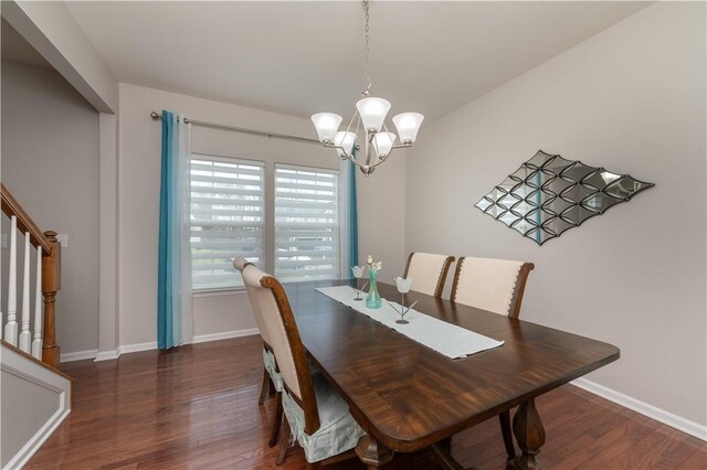 dining space featuring baseboards, an inviting chandelier, wood finished floors, and stairs