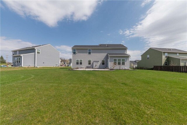 rear view of house with a lawn and a patio