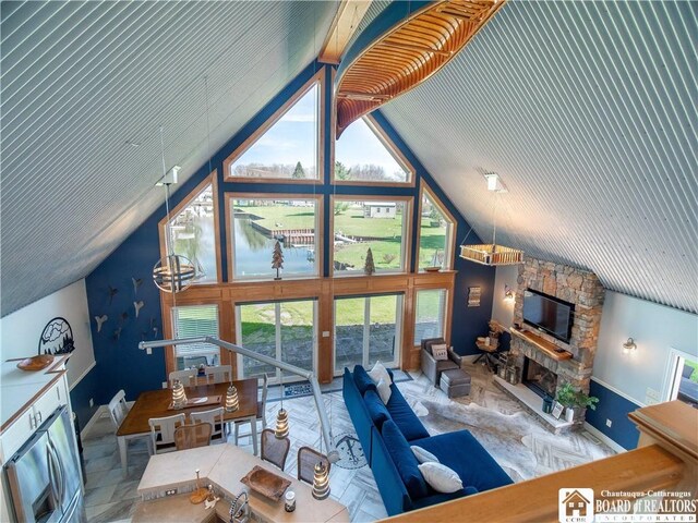 living area with high vaulted ceiling, baseboards, and a fireplace