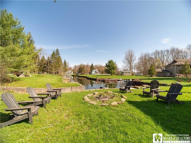 surrounding community with a lawn and a water view