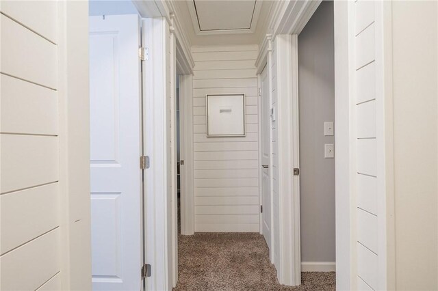 corridor with carpet, crown molding, and baseboards