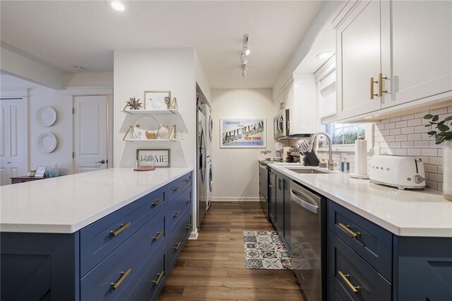 kitchen with stainless steel appliances, light countertops, a sink, decorative backsplash, and blue cabinetry