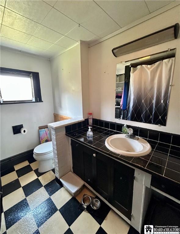 full bathroom featuring toilet, vanity, and tile patterned floors