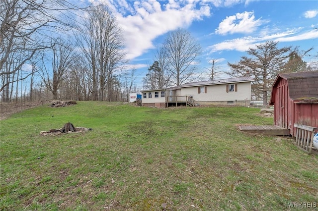 view of yard with a wooden deck, an outdoor structure, and a storage shed