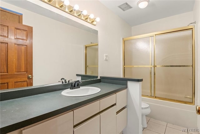 bathroom featuring combined bath / shower with glass door, vanity, toilet, tile patterned flooring, and visible vents