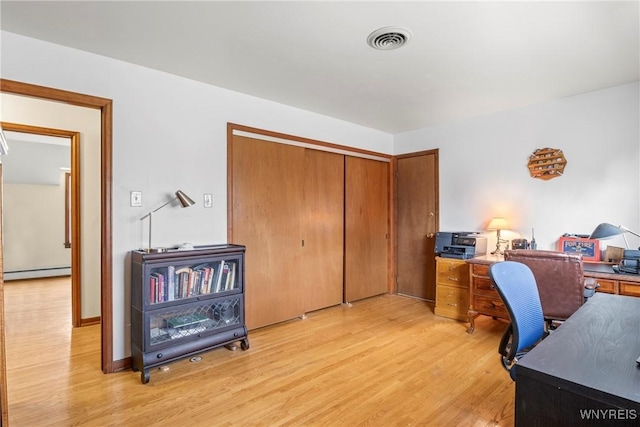 home office with baseboard heating, visible vents, and light wood finished floors