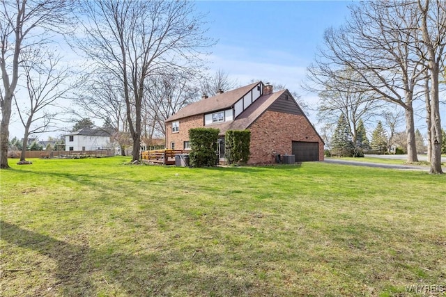 view of side of property with central air condition unit, driveway, a lawn, brick siding, and a garage