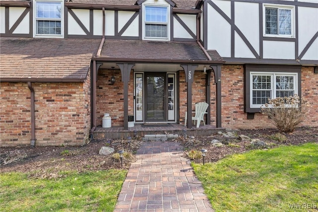 property entrance with a porch, a lawn, brick siding, and stucco siding