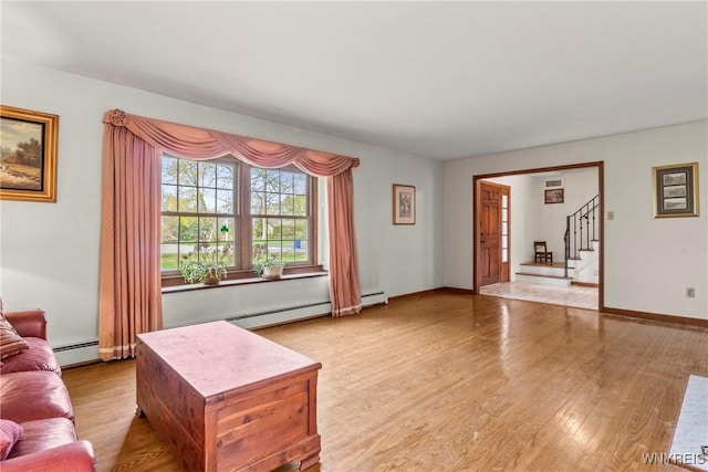 living room featuring stairway, baseboards, wood finished floors, and a baseboard radiator