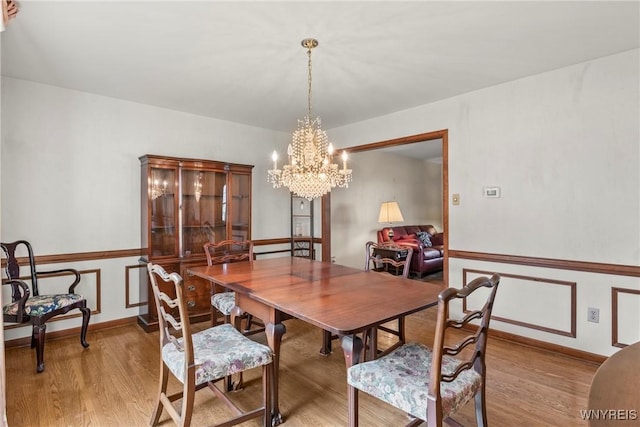 dining room with a notable chandelier and light wood-style flooring