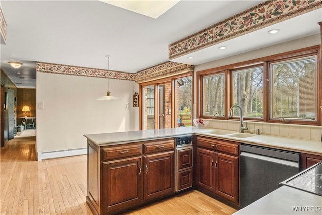 kitchen with baseboard heating, hanging light fixtures, a sink, light wood-type flooring, and dishwasher