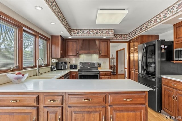 kitchen featuring stainless steel appliances, a sink, tasteful backsplash, custom exhaust hood, and light countertops