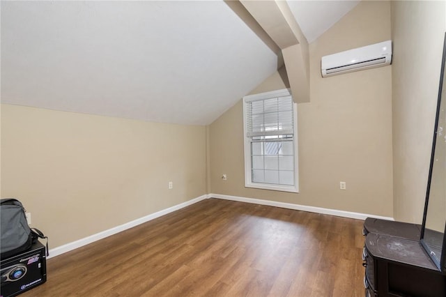additional living space with an AC wall unit, lofted ceiling, wood finished floors, and baseboards