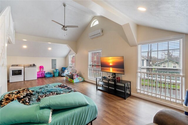 living room with electric panel, a wall unit AC, separate washer and dryer, a ceiling fan, and wood finished floors