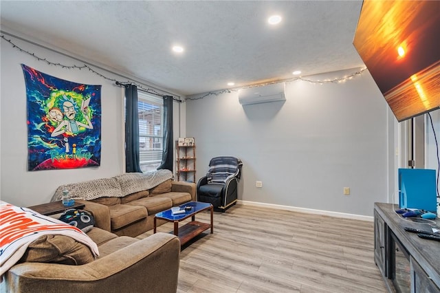 living room featuring recessed lighting, a wall mounted air conditioner, baseboards, and light wood-type flooring