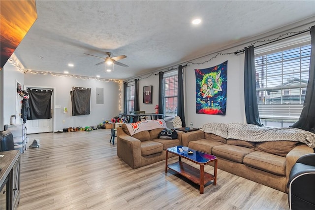 living room with ceiling fan, recessed lighting, a textured ceiling, and light wood-type flooring