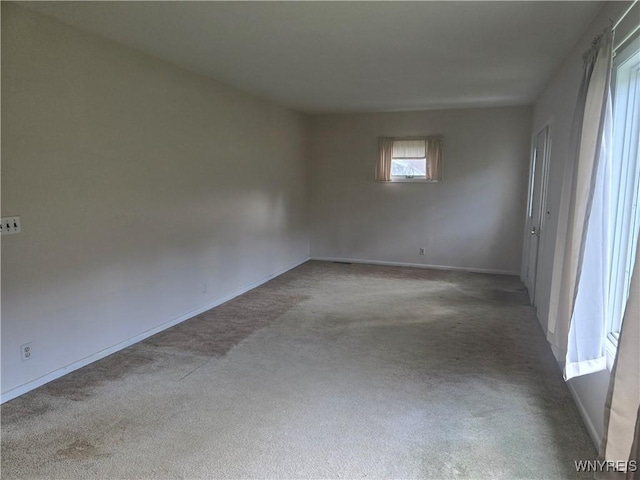 carpeted spare room featuring baseboards