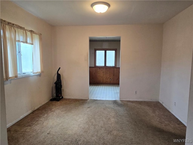 empty room featuring baseboards and carpet floors