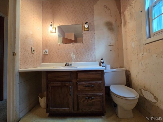 bathroom featuring wallpapered walls, vanity, and toilet