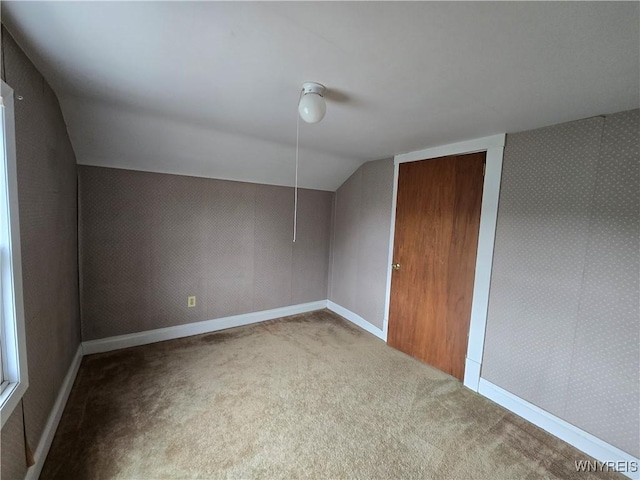 bonus room with carpet floors, lofted ceiling, and baseboards