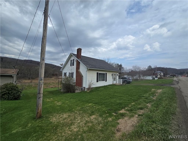 view of home's exterior featuring a lawn and a chimney