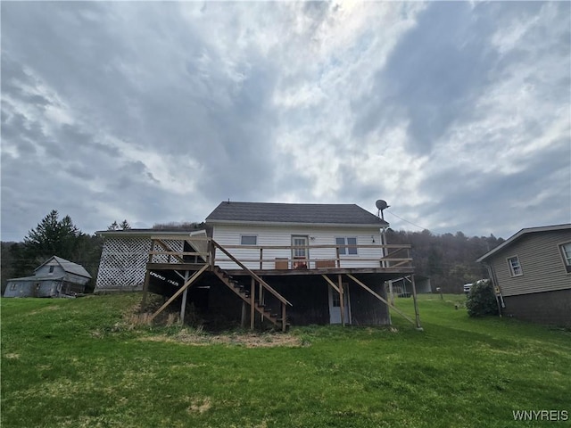 rear view of house featuring a wooden deck, a lawn, and stairs