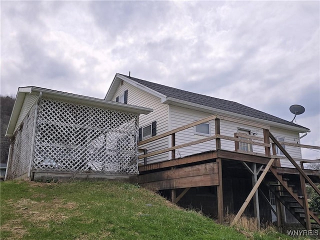 view of property exterior featuring a wooden deck and stairs