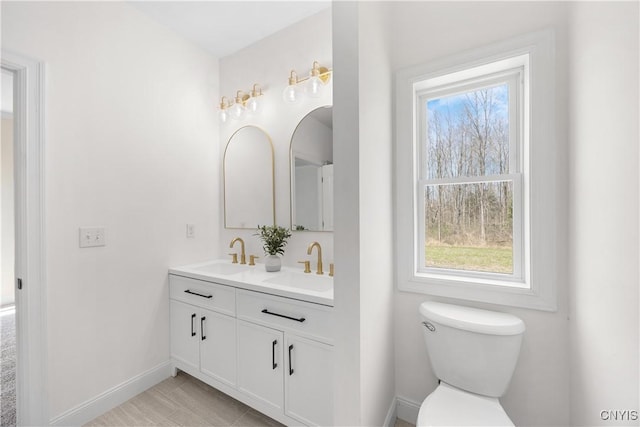7717 Roberts St, Lenox, NY 13032 - bathroom with baseboards, a sink, double vanity, and toilet