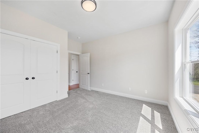 7717 Roberts St, Lenox, NY 13032 - unfurnished bedroom featuring light colored carpet, baseboards, multiple windows, and a closet