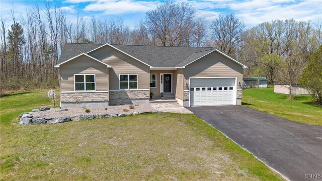 7717 Roberts St, Lenox, NY 13032 - view of front of house featuring a front lawn, stone siding, an attached garage, a shingled roof, and aphalt driveway