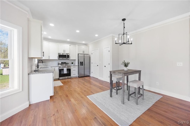 7717 Roberts St, Lenox, NY 13032 - kitchen with crown molding, a sink, stainless steel appliances, baseboards, and a notable chandelier