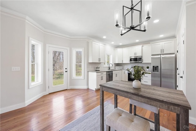 7717 Roberts St, Lenox, NY 13032 - kitchen featuring white cabinets, stainless steel appliances, a sink, a notable chandelier, and light countertops